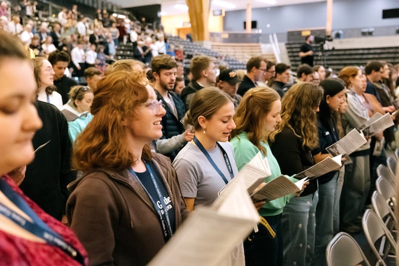 Des jeunes adultes se tiennent debout pour chanter lors d'une réunion spirituelle commémorant les « 100 ans d'institut » tenue dans l'ICCU Arena sur le campus de l'université d'Idaho à Moscow (Idaho), le samedi 26 septembre 2026.