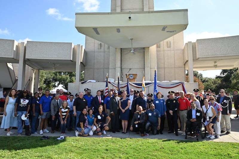 Des bénévoles posent pour une photo aux côtés de dirigeants civiques et religieux lors d'un événement de la Journée nationale du service et du souvenir à Houston, au Texas, au cimetière national de Houston, le samedi 12 septembre 2026.