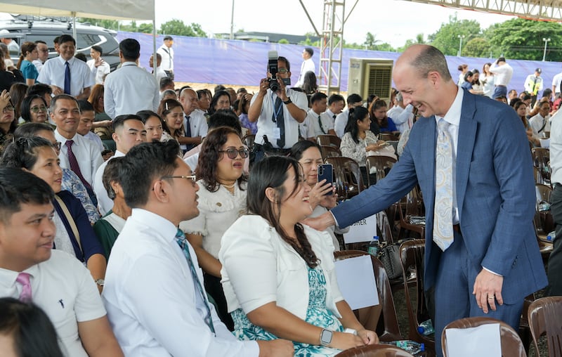 Le frère Steven D. Shumway — soixante-dix Autorité générale et membre de la présidence de l'interrégion des Philippines, à droite — salue les invités et les personnes présentes lors de la cérémonie d'ouverture du chantier du temple de Naga (Philippines), le 8 août 2026, à Naga City (Philippines).