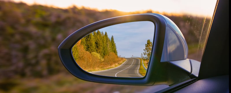 La vue sur les montagnes dans le rétroviseur extérieur d'une voiture.