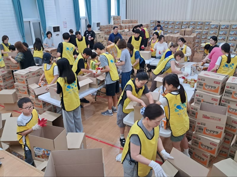 Des membres du pieu de Busan (Corée) préparent des colis pour les personnes âgées à Busan (Corée du Sud), le 13 juillet 2026.