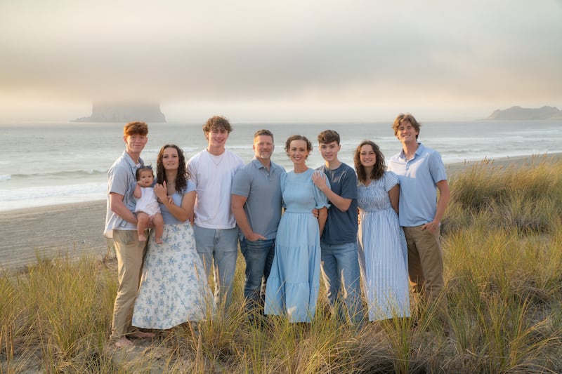 Neuf membres de la famille Anglesey prennent une photo ensemble lors d'un voyage à Pacific City, Oregon, en septembre 2025.