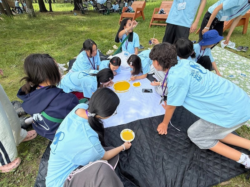 Des participants à une conférence Jeunes, soyez forts près d’Oulan-Bator, en Mongolie, créent un drapeau d’équipe le 28 juin 2026.