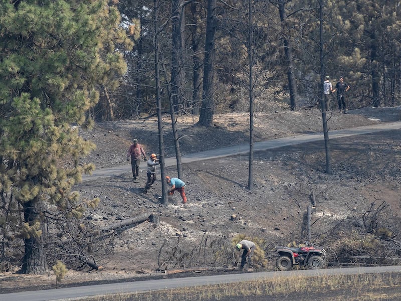 Des jeunes gens et des dirigeants du pieu de Mount Spokane (Spokane, Washington) aident à déblayer les débris d'un quartier endommagé par des incendies de forêt à Spokane (Washington), le lundi 3 août 2026.