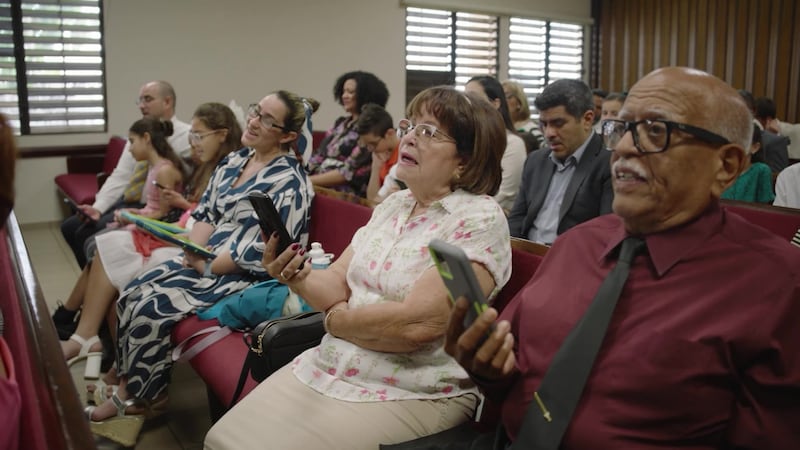 Des membres de l’Église à Porto Rico chantent en utilisant leur téléphone pendant leur réunion de Sainte-Cène.