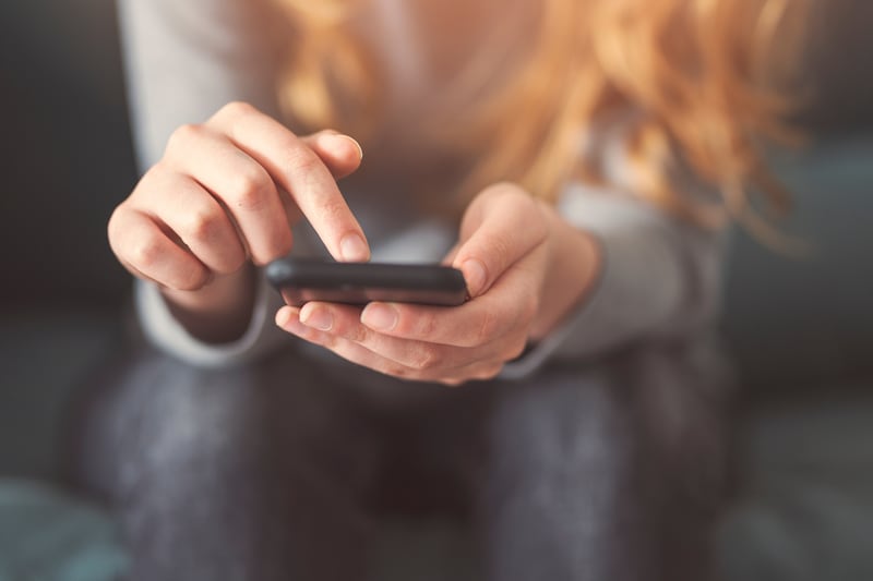 Une jeune femme regarde son téléphone.