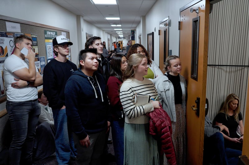Des jeunes écoutent une réunion spirituelle dans le couloir.