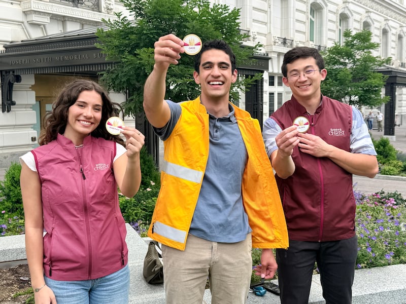 Des bénévoles montrent leurs badges pour la célébration du temple de Salt Lake en 2027.