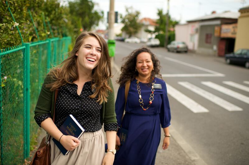 Deux soeurs missionnaires en Roumanie rient en marchant ensemble dans une rue.
