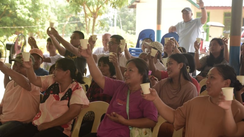Des membres de la communaute levent leur verre pour celebrer l'eau potable aux Philippines le 23 avril 2026.