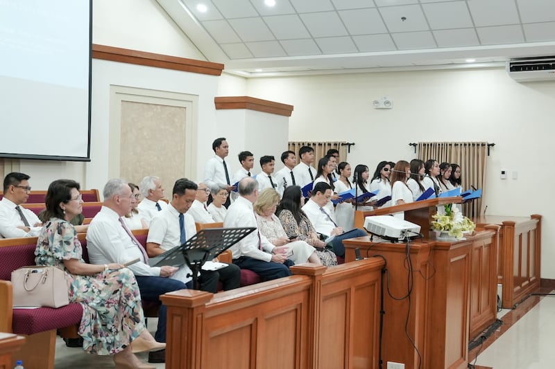 Frère Ulisses Soares, du Collège des douze apôtres, et son épouse, sœur Rosana Soares, à gauche, écoutent une chorale lors d'une réunion spirituelle pour jeunes adultes à Cebu, le 16 mai 2026.