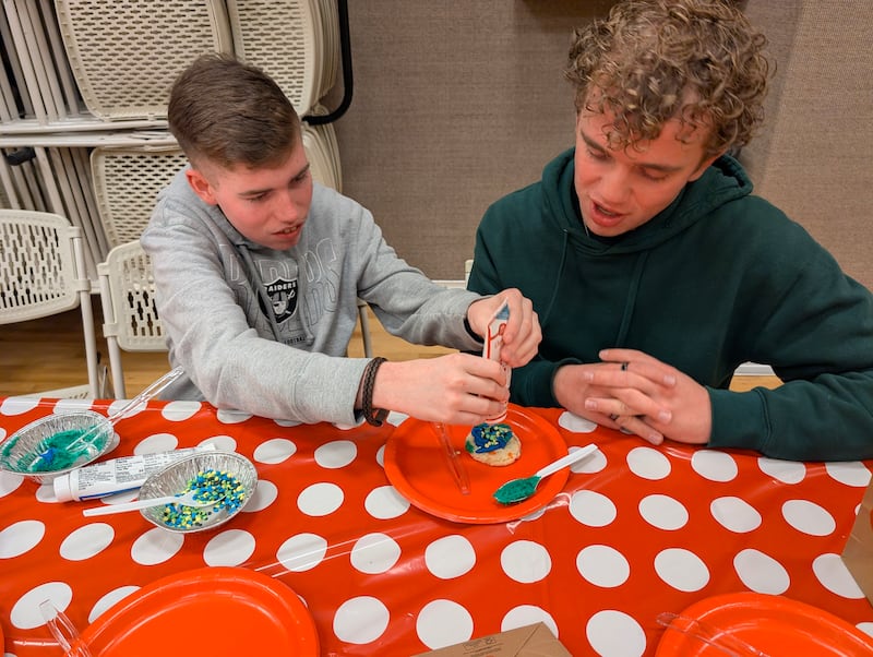Un participant et un conseiller des jeunes décorent des biscuits pendant le programme d'activités pour personnes handicapées à Las Vegas (Nevada), en février 2026.