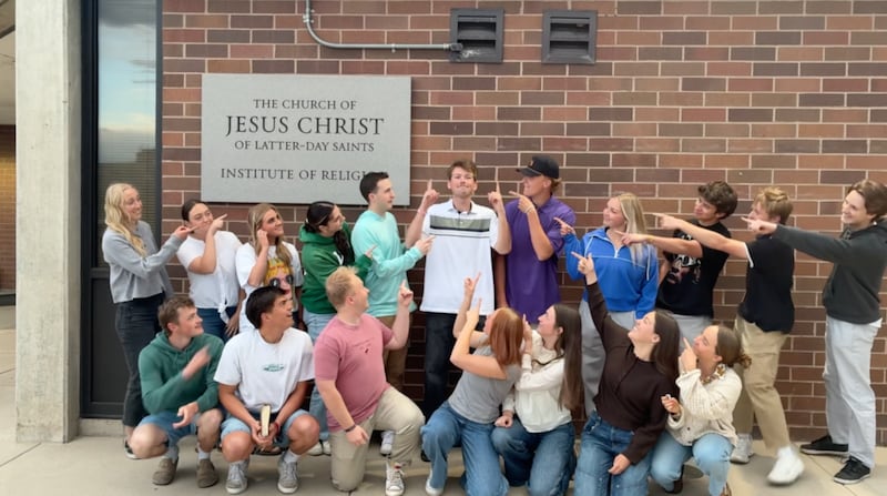 Kaleb Jones, au centre, pointe vers le ciel tandis que d'autres jeunes adultes le désignent du doigt dans une vidéo tournée à l'institut de religion d'Utah Valley à Orem, en Utah, en 2026.