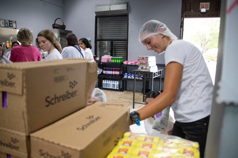 Des jeunes emballent de la nourriture lors d'une activité de service communautaire à Naguabo, à Porto Rico, le samedi 16 mai 2026.