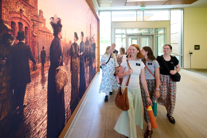 Des sœurs missionnaires passent devant une nouvelle peinture murale représentant les premières sœurs missionnaires célibataires de cette dispensation, au centre de formation des missionnaires de Provo, à Provo (Utah), le 19 juin 2026.