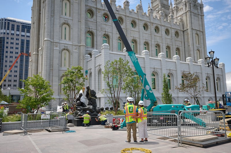 Des équipes installent la statue Jésus et la Samaritaine à Temple Square, à Salt Lake City, le mercredi 15 juillet 2026.