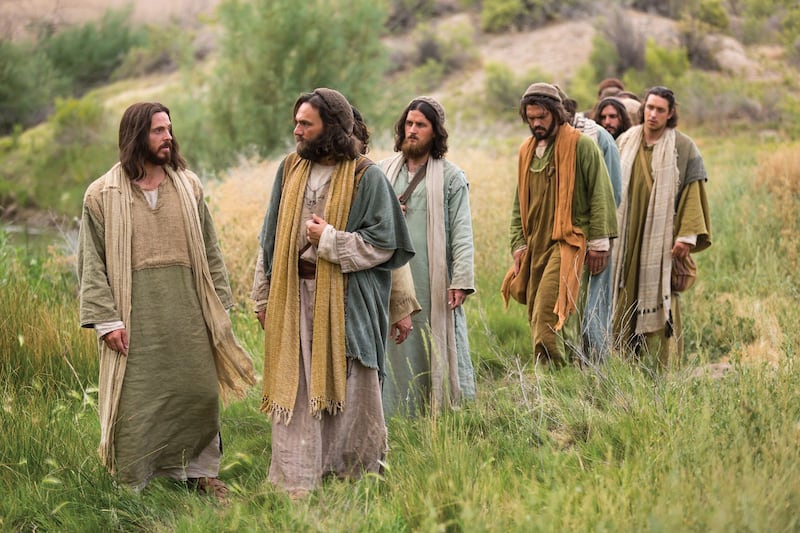 Des acteurs incarnant Jésus-Christ et les apôtres marchent pendant que Jésus, à gauche, les instruit dans cette scène tirée des Vidéos de la Bible illustrant Matthieu 16.