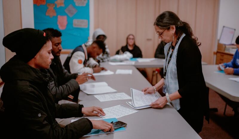 Un instructeur, à droite, enseigne lors d'un cours d'anglais langue seconde dispensé au centre d'amitié et d'entraide de Wembley.
