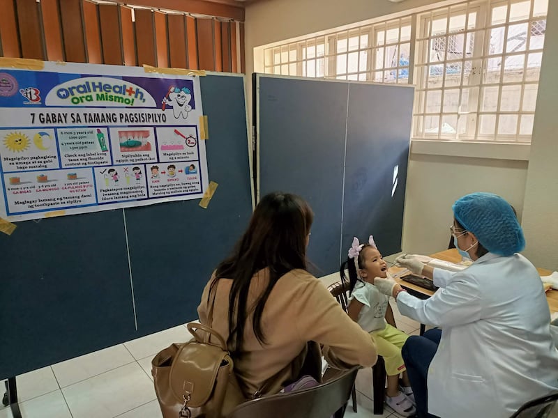 Une travailleuse de la santé vérifie les dents d'une fille lors d'un dépistage organisé au centre de pieu de Caloocan, aux Philippines, le 24 janvier 2026.
