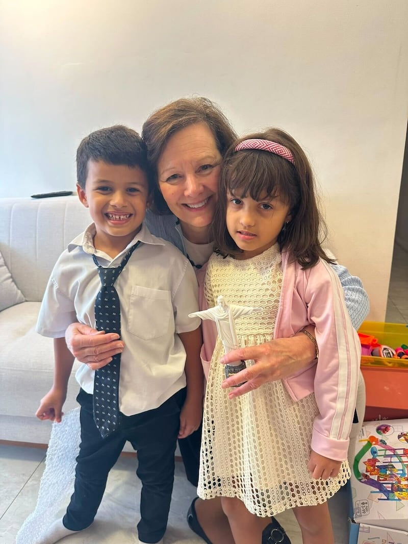 La présidente générale de la Primaire, Susan H. Porter, au centre, prend une photo avec deux enfants au Brésil, le samedi 13 juin 2026.