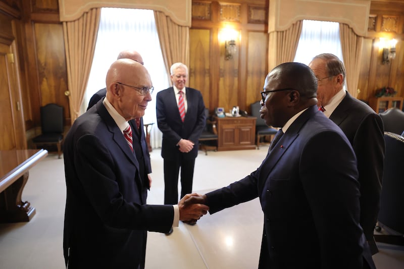 Le président Dallin H. Oaks serre la main de l'ambassadeur de la Côte d'Ivoire aux États-Unis au siège de l'Église à Salt Lake City, Utah, sous le regard du président Henry B. Eyring et de frère D. Todd Christofferson.