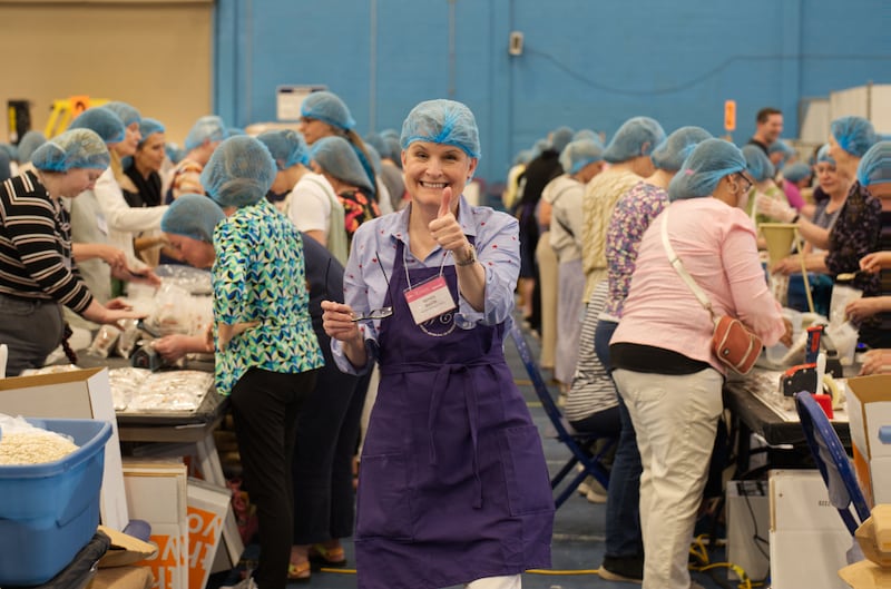 Des femmes emballent des repas pour Hunger Fight lors de la soirée de service à la conférence des femmes de BYU 2024.