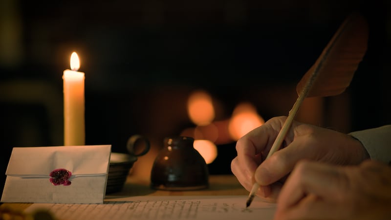 Un homme ecrit une lettre avec une plume d'oie, avec un feu en arriere-plan.