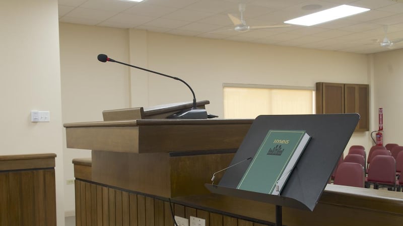 Un recueil de cantiques et un pupitre reposent près de la chaire dans une nouvelle église pour les membres de la paroisse de Curepe du pieu de Port of Spain (Trinité) de l'Église de Jésus-Christ des Saints des Derniers Jours, à Arima (Trinité-et-Tobago), en juillet 2026.