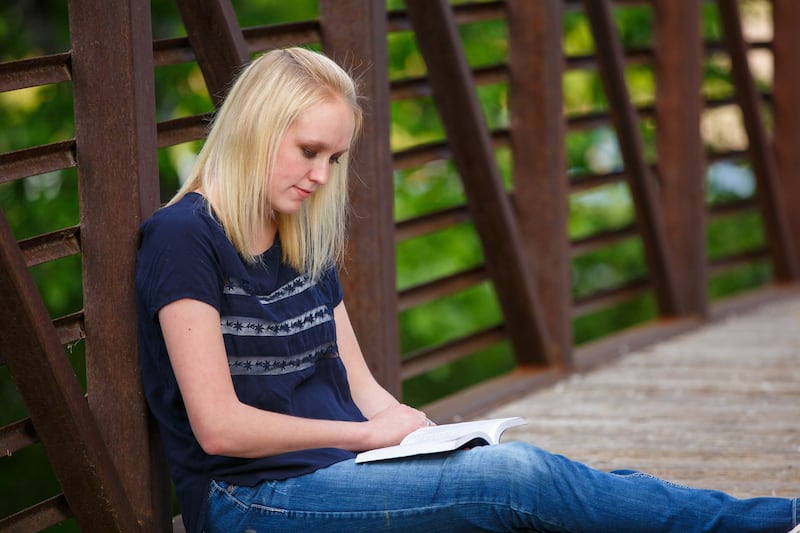 Une jeune femme lit les Écritures.