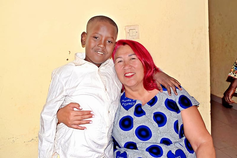 Une femme serre un jeune homme dans ses bras pendant qu'il attend son tour pour être baptisé à Bamako, au Mali, le 18 avril 2026.
