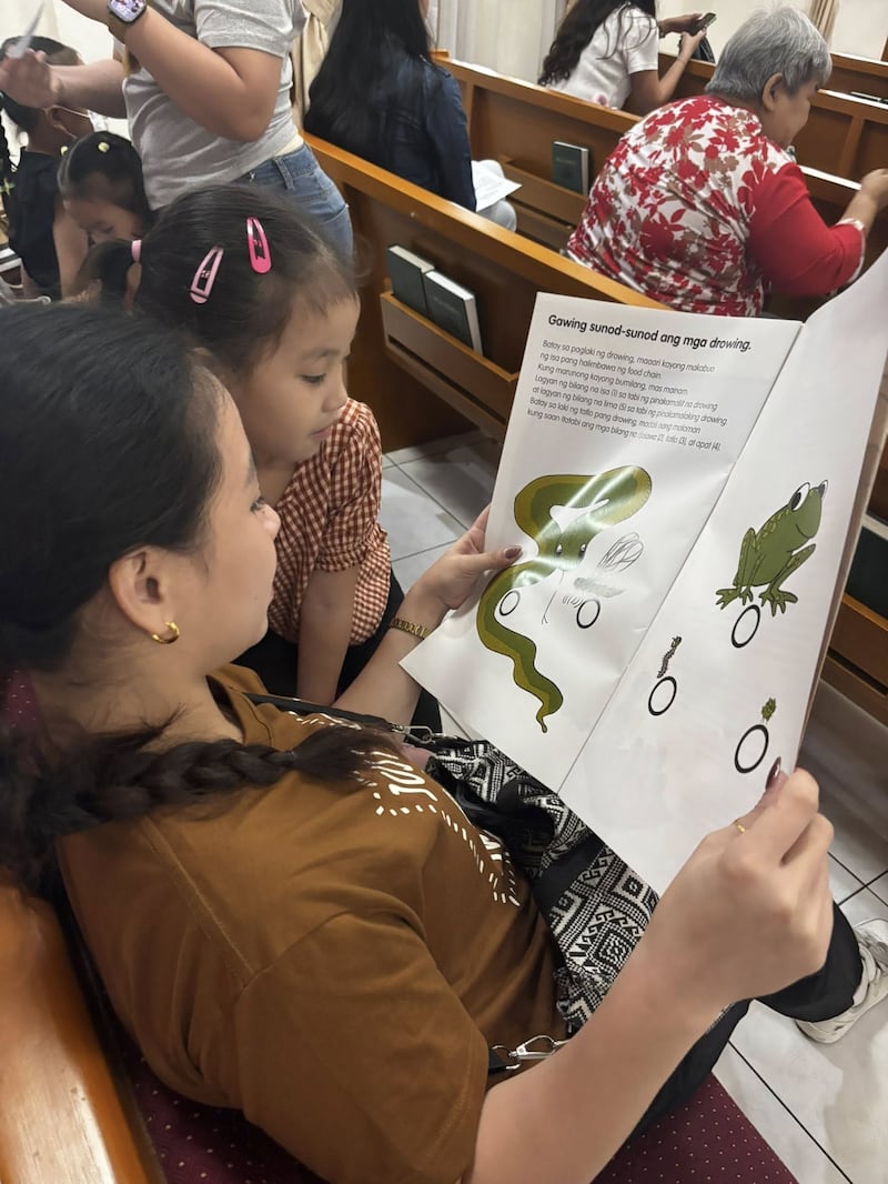 Une mère et son enfant lisent un livre sur la nutrition lors de la première séance de dépistage du Programme de nutrition infantile, tenue au centre de pieu de Caloocan, aux Philippines, le 24 janvier 2026.