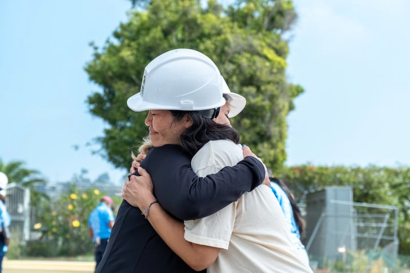 Des bénévoles se prennent dans les bras lors d'une initiative de Habitat for Humanity visant à reconstruire des maisons détruites par l'incendie de Palisades, au cours d'un événement de quatre jours en septembre 2026 à Los Angeles, en Californie.