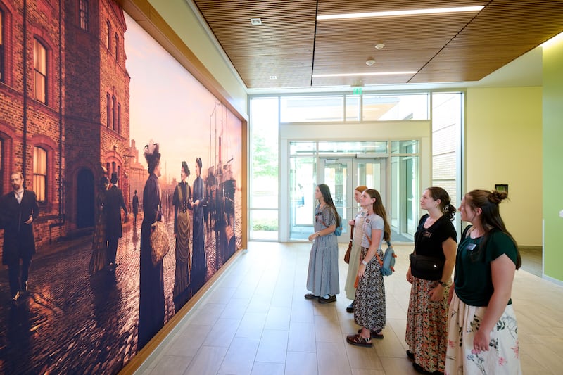 Des sœurs missionnaires regardent une peinture murale représentant les premières sœurs missionnaires célibataires de cette dispensation au centre de formation des missionnaires de Provo, à Provo (Utah), le 19 juin 2026.