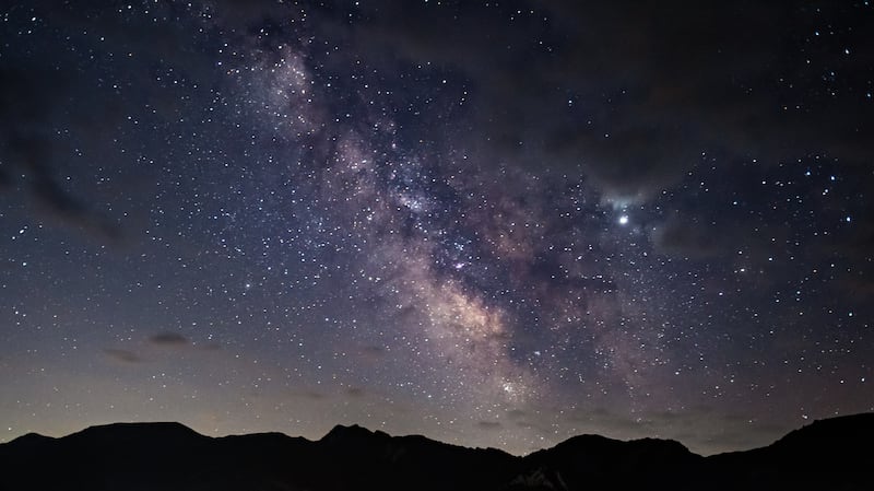 La Voie lactée vue au-dessus des sommets montagneux.