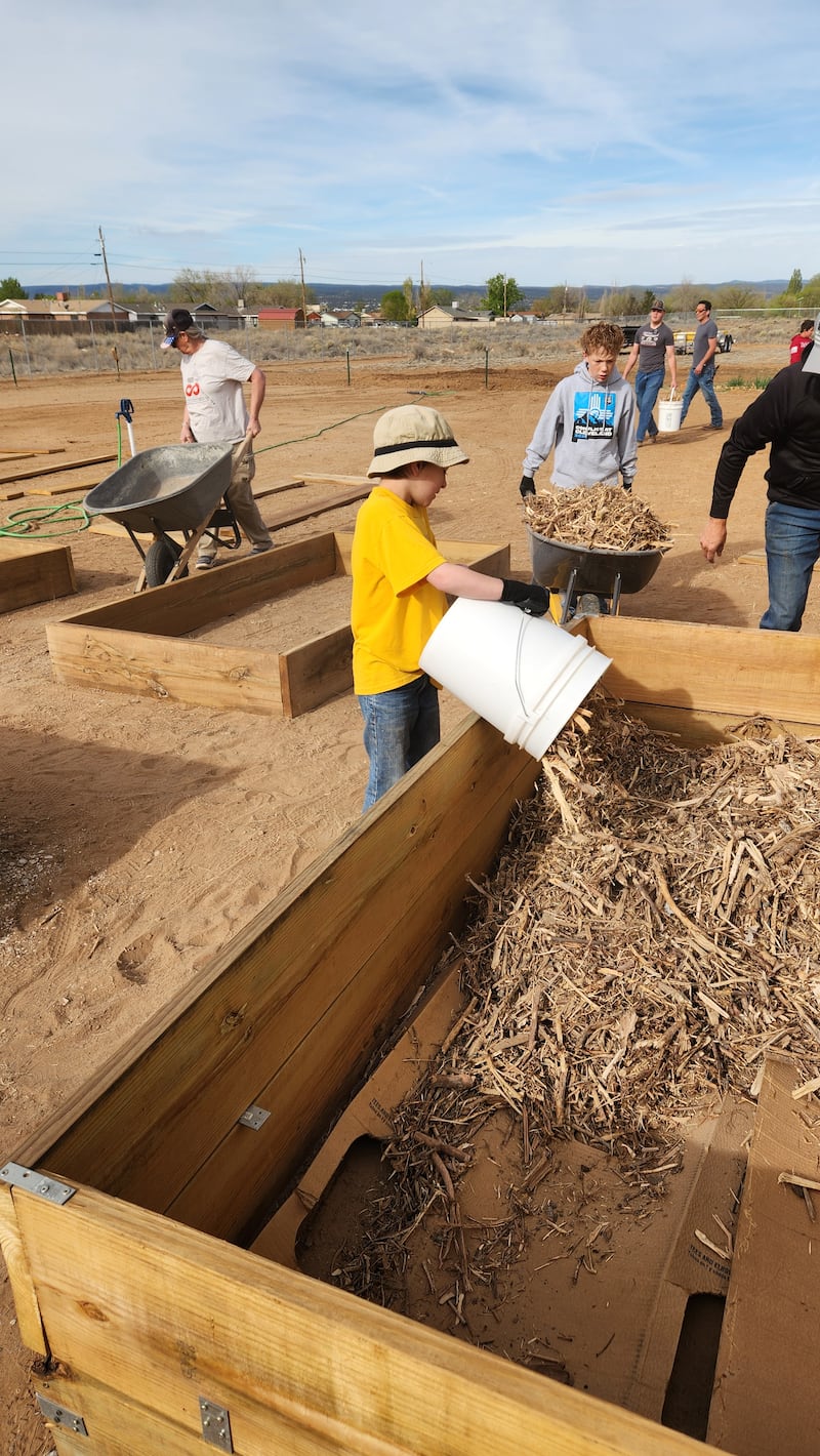 Des jeunes et des adultes préparent de nouveaux bacs de jardinage au Community Pantry et au Hope Garden à Grants, au Nouveau-Mexique, le 11 avril 2026.