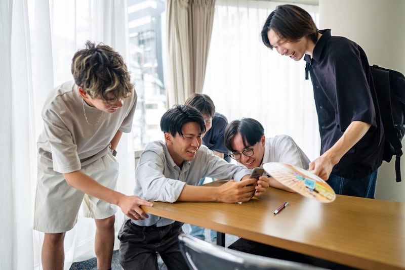 De jeunes adultes japonais discutent ensemble.