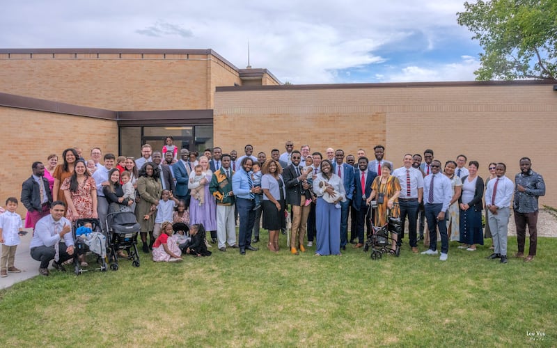 Des membres de la 35e paroisse de Lehi (française) du pieu central de Lehi (Utah) posent pour une photo devant l'église après une bénédiction d'enfant, le 3 mai 2026, à Lehi (Utah).