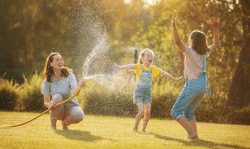 Une mère joue dehors avec ses filles.