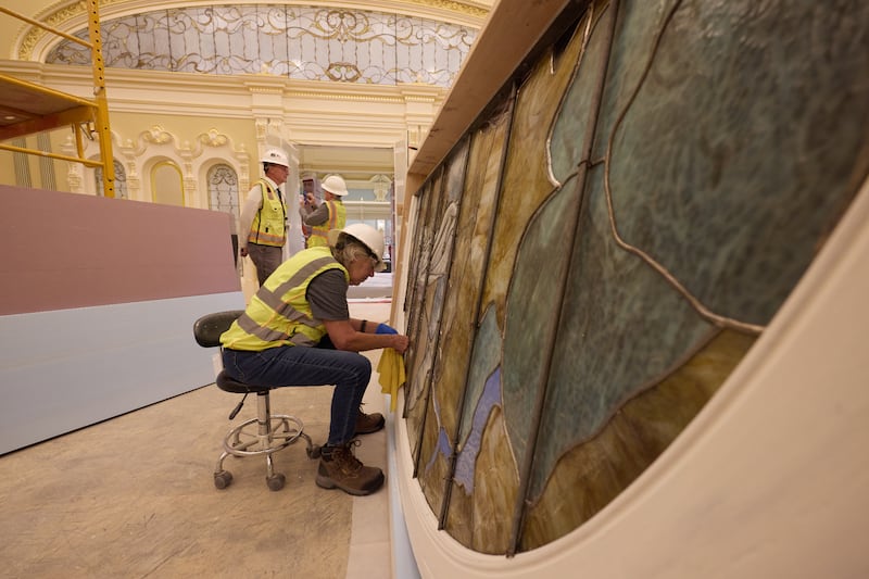 Lors de l'installation, un ouvrier nettoie une pièce de verre d'art représentant Adam et Ève le mardi 21 avril 2026, à Salt Lake City. L'œuvre d'art sera dans la salle céleste du temple de Salt Lake.