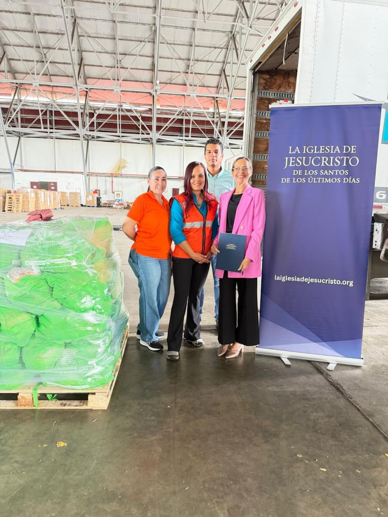 Des membres de l'Église de Jésus-Christ des Saints des Derniers Jours posent pour une photo à côté de kits d'aide d'urgence offerts à des familles dans le besoin à Panama (Panama), le 15 octobre 2026, après qu'un séisme a frappé le pays cinq jours plus tôt.