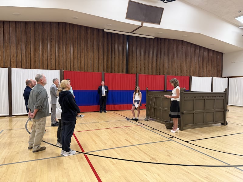 Deux jeunes femmes de l'Église de Jésus-Christ des Saints des Derniers Jours expliquent l'autel du sacrifice à un groupe de visiteurs dans la réplique de la cour du tabernacle au pieu de Farmington Utah North, le 18 juin 2026.