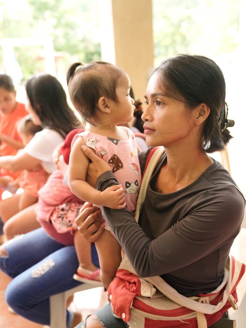 Une mère et son enfant participent à un dépistage nutritionnel aux Philippines, août 2025.