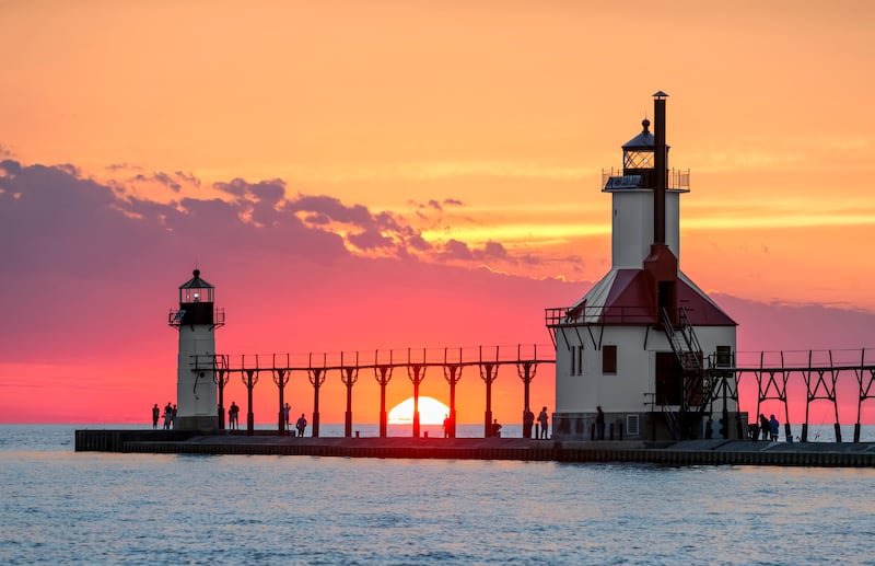 Au solstice d’été, le soleil se couche sur le lac Michigan entre les phares intérieur et extérieur de la jetée nord à St. Joseph, dans le Michigan.