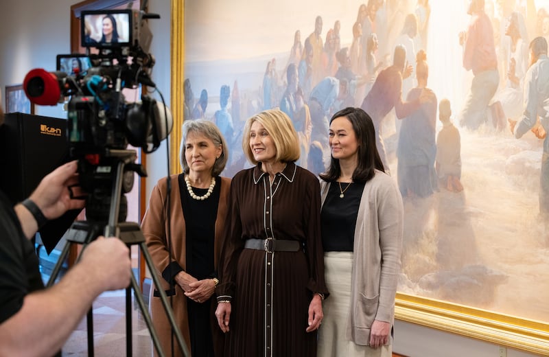La présidence générale de la Société de Secours filme une partie de la réunion spirituelle mondiale de la Société de Secours de 2026 devant une grande peinture dans le Centre de conférences à Salt Lake City.