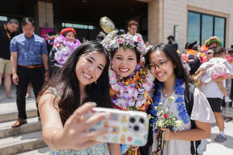 Des diplomes de BYU-Hawaii prennent des photos devant le Cannon Activities Center apres la ceremonie de remise des diplomes le vendredi 17 avril 2026, a Laie, Hawaii.