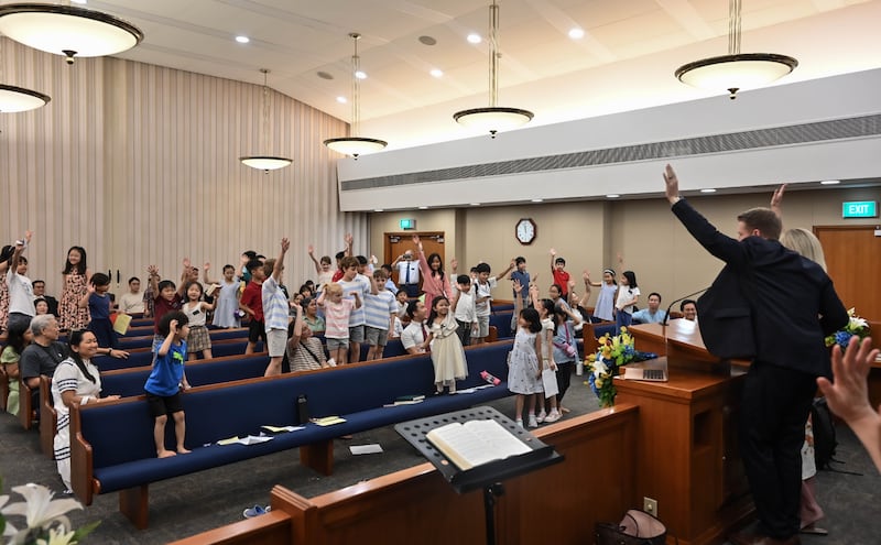 Pendant son ministère à Singapour, le président général des Jeunes Gens Timothy L. Farnes a invité des enfants à se lever, à lever la main et à s'engager à lire les Écritures tous les jours.