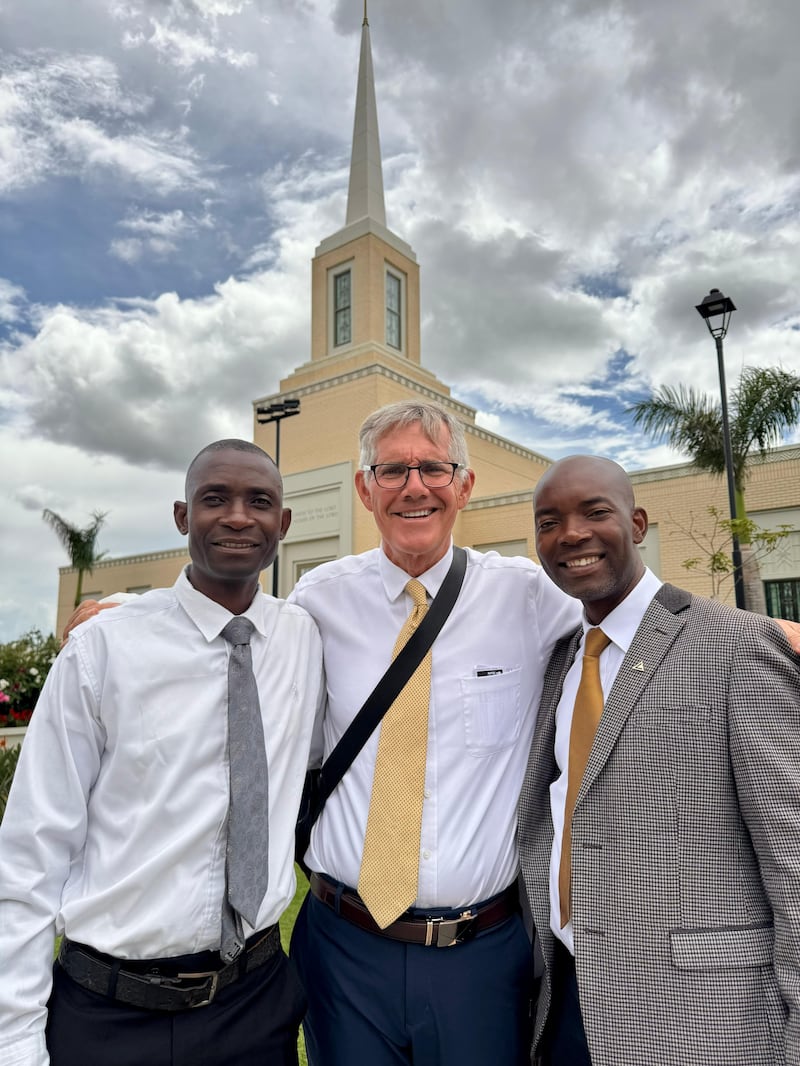 Trois hommes se tiennent devant le temple de Harare, au Zimbabwe.