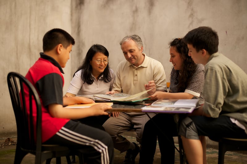 Une famille d'Argentine assise en train de regarder des documents d'histoire de la famille.