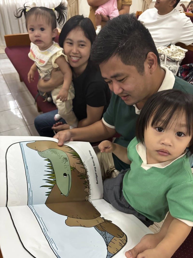 Une famille lit un livre sur la nutrition lors de la première évaluation du Programme de nutrition infantile tenue au centre de pieu de Caloocan, aux Philippines, le 24 janvier 2026.