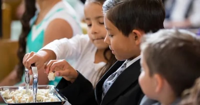 Des enfants prennent la Sainte-Cène.